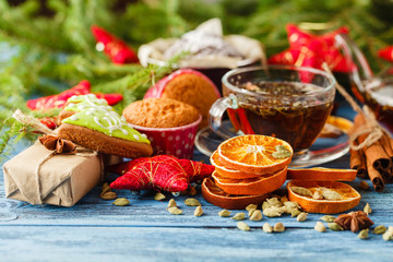 cup of hot tea and a teapot. cinnamon, anise, cookies and spruce