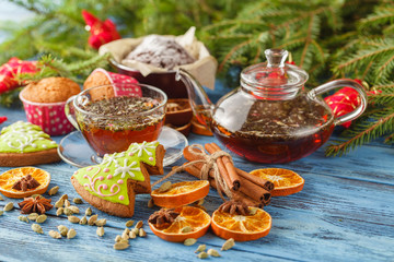 Mulled tea with spices and festive Christmas decorations on wood