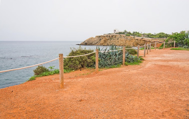 Seaside fence on red earth Es Canar