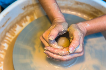 womens hands of a potter creating an earthen jar