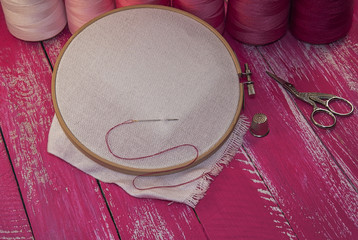 thread and  fabric in the wooden embroidery frame for needlework