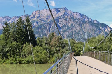 Pedestrian bridge over the Salzach river in Puch, not far from Salzburg city. In the background the mountain Untersberg. Puch, Austria, Europe.