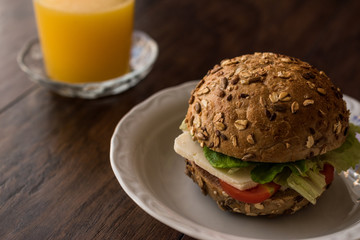 Light Sandwich with tomato, cheese and a orange juice..