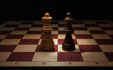 Wooden chess. Black and White Queen on chess board.