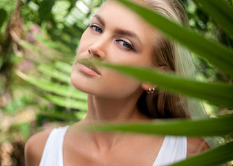 Naklejka premium Girl portrait against a background of a palm leaf