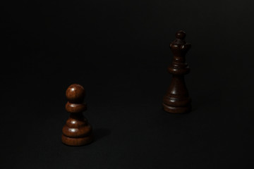 Chess. Black Pawn and Queen on black background.