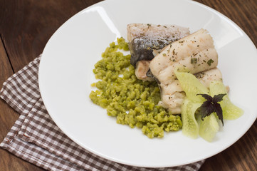 Boiled fish steak with pea puree. Wooden background. Top view. Close-up
