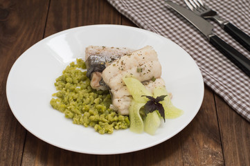 Boiled fish steak with pea puree. Wooden background. Top view. Close-up