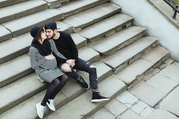 Man and pregnant woman sitting on stairs