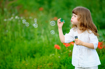 cute child starts soap bubbles
