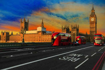 Fototapeta na wymiar London, England, UK. Red buses blured in motion on Westminster bridge with Big Ben, the Palace of Westminster in early morning before sunrise.