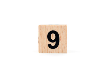 Wooden block Number nine on white background.