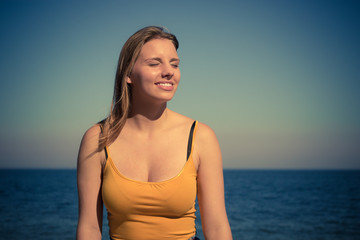 Lovely blonde girl relaxing outdoor by seaside