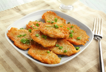 Plate with tasty potato pancakes for Hanukkah on kitchen table