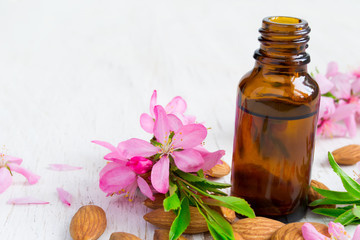 Obraz na płótnie Canvas Almond essential oil, flowers and nuts