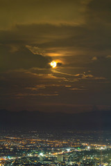 Supermoon raising up in the sky over the sky at night