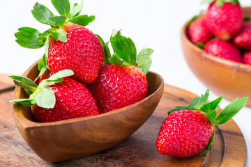 Ripe strawberries in a big wooden bowl, close-up, selective focu