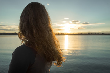 Girl Looking at Sunset Over Lake
