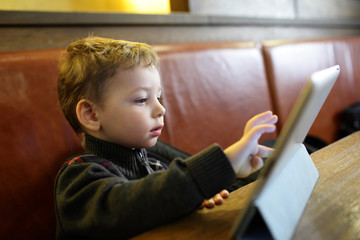 Fototapeta na wymiar Kid playing on a Tablet PC