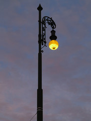 Street lamp shining at dusk