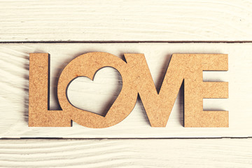 Love word decoration made of wood on retro planks as background