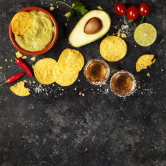 Bowl of mexican nachos chips with homemade fresh guacomole sauce