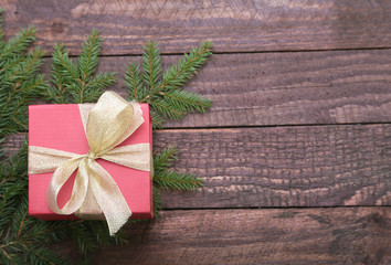 Christmas fir tree with gift box on wooden board