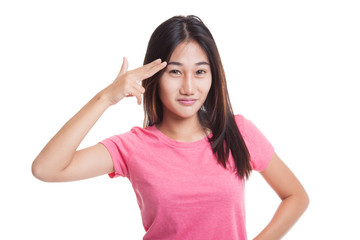 Beautiful young Asian woman holding fingers in gun gesture..