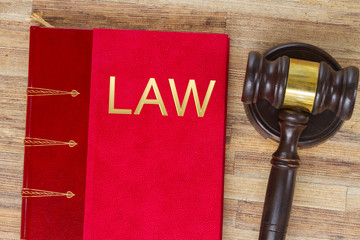 Wooden Law Gavel and legal book on wooden desktop with word Law, top view