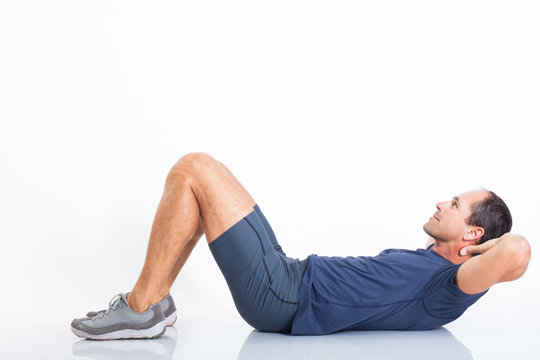 homme sportif sur fond blanc faisant des exercices d'abdominaux