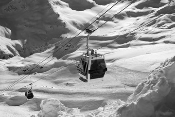 Black and white view on ski lift in snow mountains