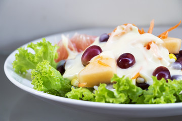 Fruit salad in a white dish.