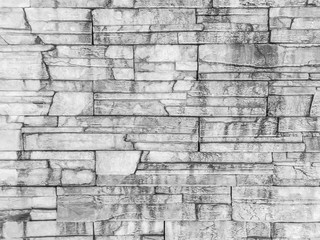 Fototapeta premium Closeup surface brick pattern at old and dirty wet stone brick wall textured background in black and white tone