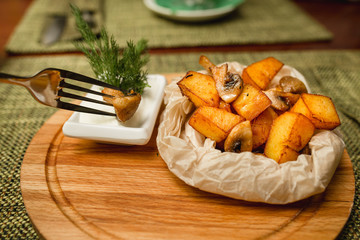 Fried potatoes with mushrooms. Fork dunk in the sauce