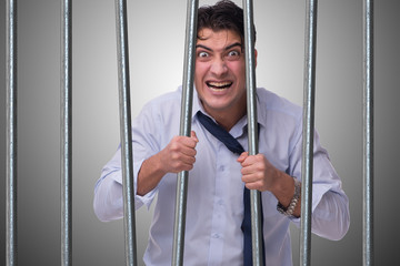 Young businessman behind the bars in prison