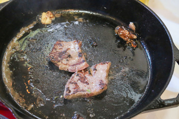 Raw beef meat steak grilling in a fry pan