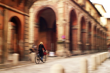 woman cyclist riding in bologna's streets © francescograssi