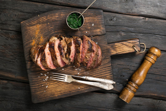 Grilled Steak on cutting board with chimichurri sauce