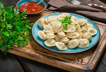 Blue plate with ravioli and parsel close up