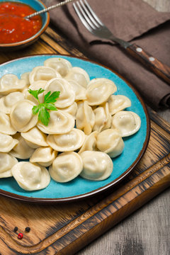 Ravioli With Red Sauce On Dark Wooden Table