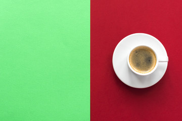 little white cup of aromatic black coffee on red vinous background and nothing  on green background