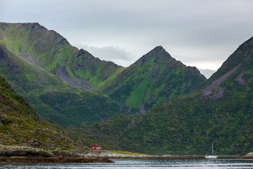 A sailboat in a fjord surrounded by steep mountains