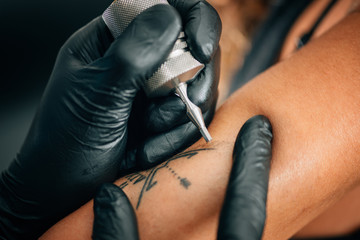 Tattoo. Tattoo artist tattooing woman