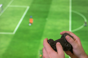 Man Holding game controller joystick while playing console game.