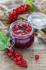 Homemade jam in a jar, red currant and old sacking.