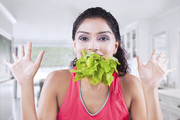 Female model with spinach on mouth