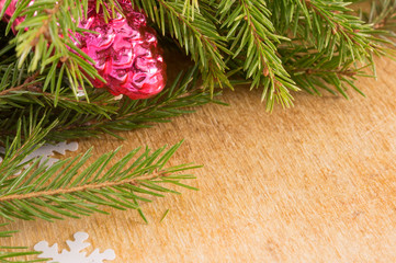 The branches of Christmas trees and  fallal cone decorations on the background of wooden boards....