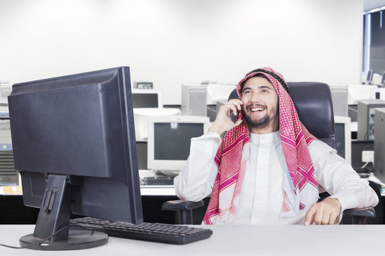 Muslim businessman speaks on smartphone