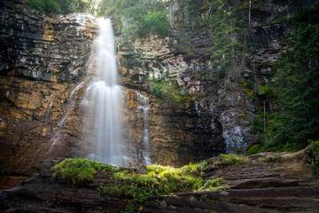 Fototapeta na wymiar Waterfall flowing into a lush valley.
