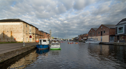 Moored in the harbor of ships and people kayaking. Exeter. England